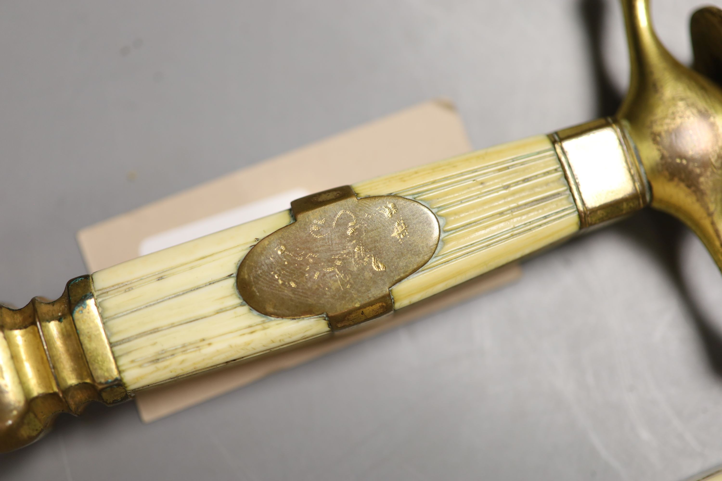 A Georgian naval dirk 41 cm flattened diamond blade etched EDWARD EDWARDS OWEN 1794-1838., Grip with engraved central copper band with traces of a rampart lion. Contained in its copper gilt mounted leather scabbard. Toge